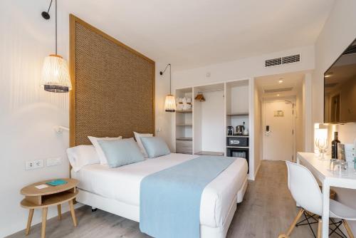 une chambre d'hôtel avec un grand lit et une cuisine dans l'établissement AluaSoul Mallorca Resort - Adults only, à Cala d´Or