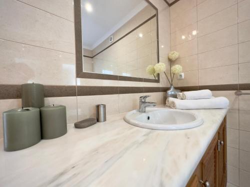 een badkamer met een wastafel en een spiegel bij Burgau Sea View, Beach & Pool Villa in Budens