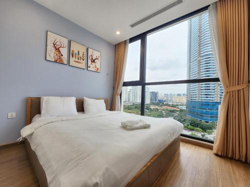 a bedroom with a large bed with a large window at Vinhomes Skylake Pham Hung-Lilyland-near Keangnam in Hanoi