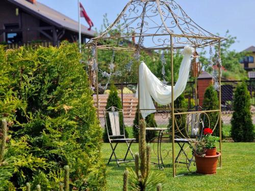 a swing in a garden with a white hammock at Family Hotel in Daugavpils