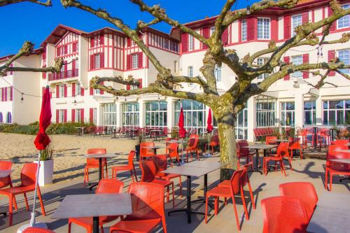 a group of tables and chairs in front of a building at Hôtel du Parc & Spa in Hossegor