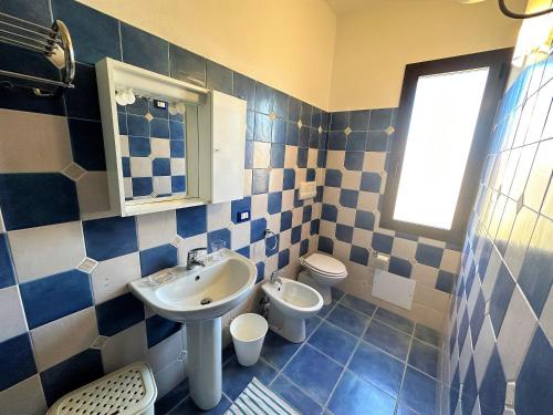 a blue and white bathroom with a sink and a toilet at Affittimoderni Valledoria Sunset - CICA10 in Valledoria