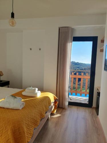 a bedroom with a bed and a large window at Quinta de Cerdeiró in Mões