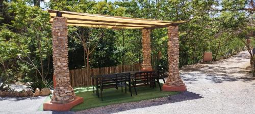 a wooden table and chairs under a pavilion at Casas Cueva y Cortijo La Tala en Guadix in Guadix