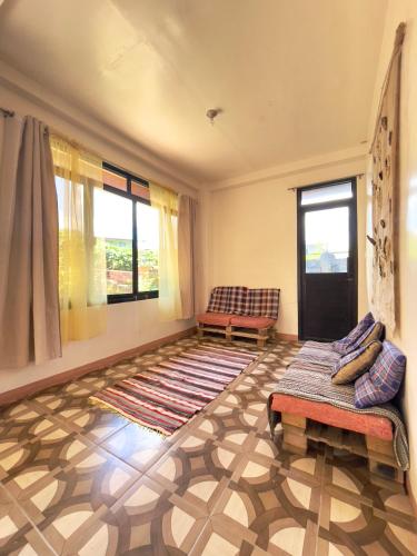 a living room with two chairs and a rug at Andrew & Mary's Lodging House in Sagada