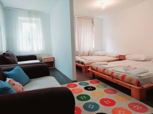 a small room with two beds and a couch and a rug at Hostel Hayat in Sarajevo