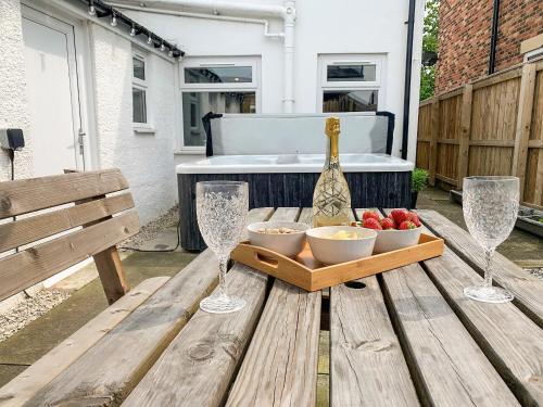 a picnic table with a bottle of wine and bowls of fruit at No 1 Overman in Bowburn