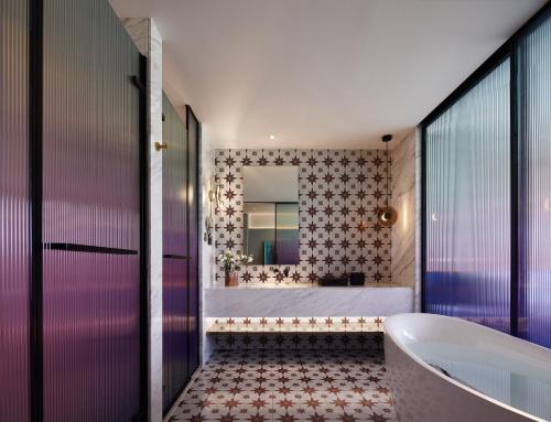 a bathroom with a tub and a large mirror at TIDE Hotel in Chaozhou