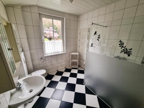 een badkamer met een zwart-wit geruite vloer bij Ferienwohnung Drewitz in Schmallenberg