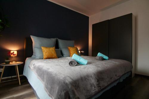 1 dormitorio con 1 cama grande con almohadas azules y naranjas en Domspatz, Top-Lage, Style, Dachterrasse, Business en Schwerin