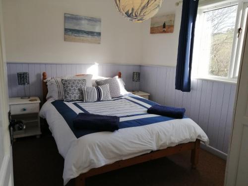 Postel nebo postele na pokoji v ubytování Badgers Den, a beautiful log cabin in a secluded valley close to the beach