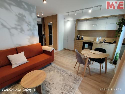 a living room with a couch and a table at MYE Apartments - Piotrkowska 44 in Łódź