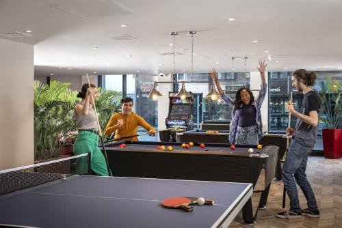 a group of people playing pool in a room at Reynard House in Leicester in Leicester