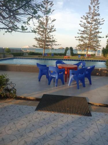 un grupo de mesas y sillas azules y rojas en Villa amir, en Sarābiyūm
