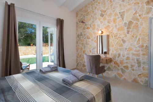 um quarto com uma cama e uma parede de pedra em Villa Irida em Plátanos