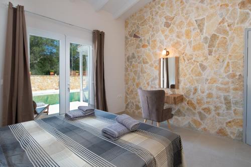 a bedroom with a bed and a stone wall at Villa Irida in Plátanos