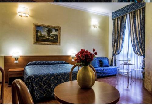 a hotel room with a bed and a vase with flowers on a table at Opera Italian Suite in Rome