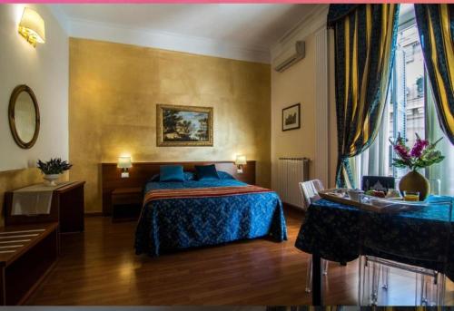 a hotel room with a bed and a table and a desk at Opera Italian Suite in Rome
