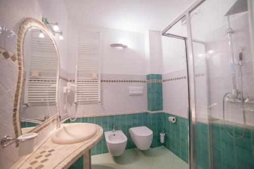 a bathroom with two toilets and a shower at Hotel Golden Gate in Bortigiadas