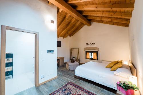a bedroom with a large white bed and wooden ceilings at SMART San Martino in Paratico