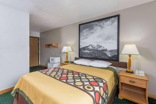 Cette petite chambre d'hôtel comprend un lit et deux lampes. dans l'établissement Super 8 by Wyndham Fairmont, à Fairmont