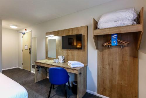 um quarto com uma secretária, uma cama, uma cama e um beliche. em Days Inn Hotel Gretna Green em Gretna Green