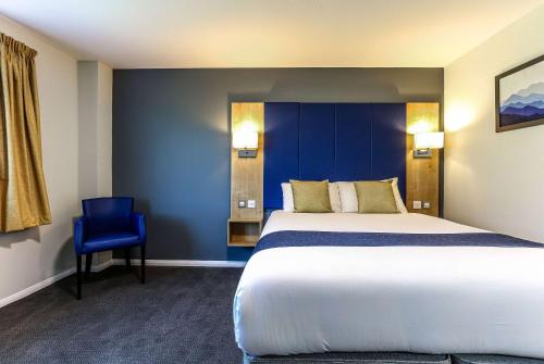 a bedroom with a large bed and a blue wall at Days Inn Hotel Gretna Green in Gretna Green