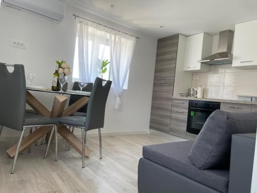 eine Küche und ein Wohnzimmer mit einem Tisch und Stühlen in der Unterkunft Apartman Toni in Skradin