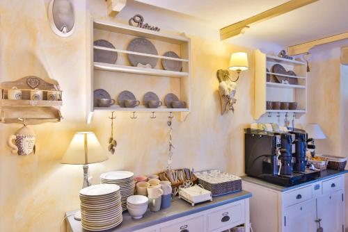 una cucina con armadi bianchi e un bancone con piatti di Hotel Il Nido a Rimini