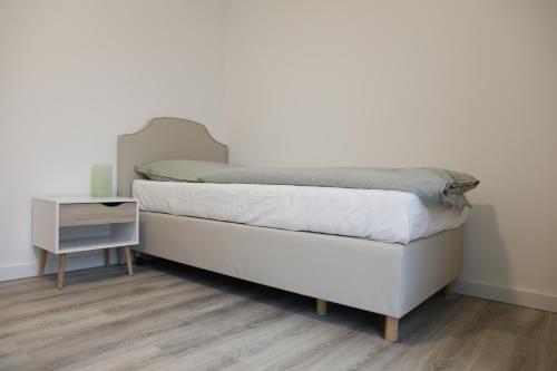 een slaapkamer met een bed en een nachtkastje ernaast bij Gästehaus Bernau OT Schönow in Bernau bei Berlin