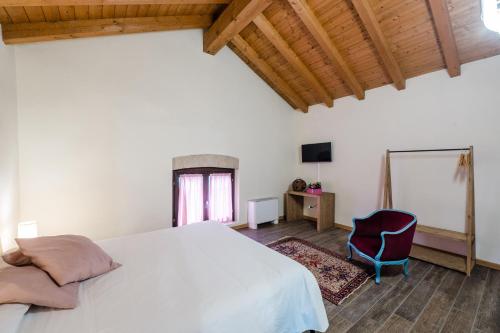 a bedroom with a white bed and a chair at SMART San Martino in Paratico