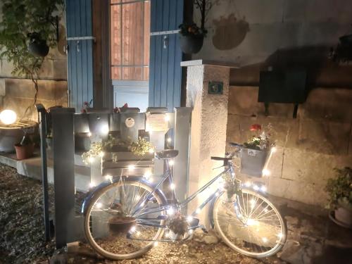 rower z lampkami świątecznymi zaparkowanymi przed domem w obiekcie La Charentaise des Lilas w mieście Saint-Léger