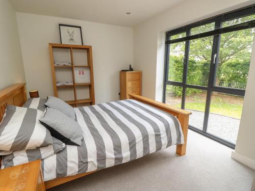 a bedroom with a bed and a large window at Appletree Cottage in Fordingbridge