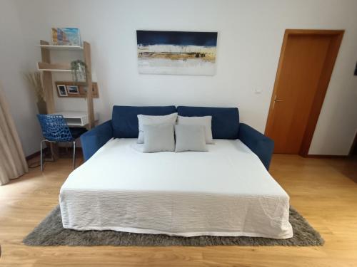 a bed with three pillows on it in a room at Stylish 1br in Gaia near Porto, sleeps 4 in Vila Nova de Gaia