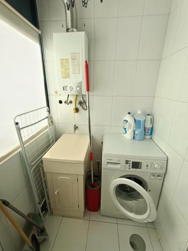 a small bathroom with a washing machine and a washer at Stylish 1br in Gaia near Porto, sleeps 4 in Vila Nova de Gaia