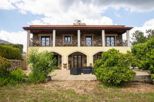 a yellow house with a balcony on top of it at Quinta da Eira Douro Valley in Fermentões