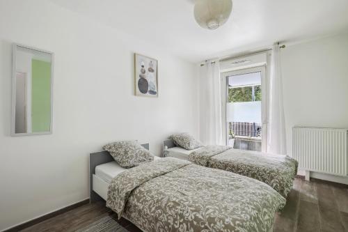 Cette chambre blanche dispose de 2 lits et d'une fenêtre. dans l'établissement Chic apart with terrace and parking, aux Ulis