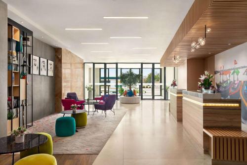 an office lobby with colorful chairs and tables at La Quinta by Wyndham Dubai Jumeirah in Dubai