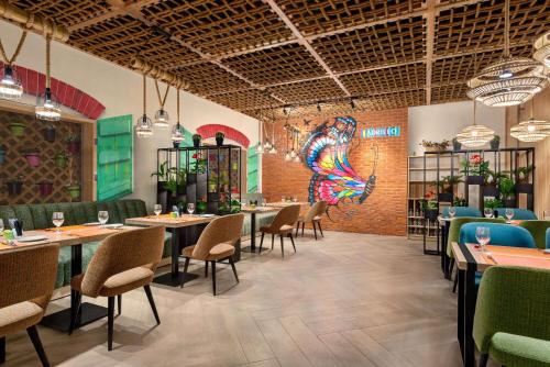 a restaurant with tables and chairs and a colorful mural at La Quinta by Wyndham Dubai Jumeirah in Dubai