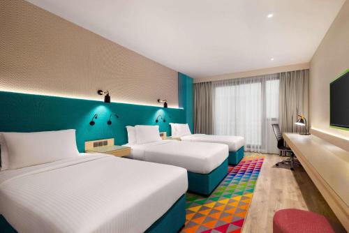 a hotel room with two beds and a flat screen tv at La Quinta by Wyndham Dubai Jumeirah in Dubai
