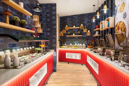 La Quinta by Wyndham Dubai Jumeirah في دبي: مطعم وجبات سريعة مع منضدة حمراء