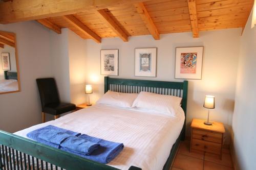 une chambre avec un grand lit et une chaise dans l'établissement Chalet The Loft, aux Gets