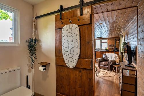 ローンセストンにあるFinest Retreats - Trevoya Cabinのサーフボード付きの木製ドアが備わる客室です。