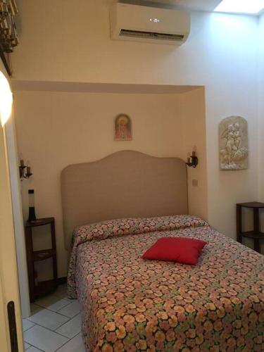 Un dormitorio con una cama con una almohada roja. en Casa vacanza, en Capri