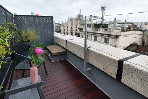 a balcony with a vase of flowers on a building at PRESTIGE BOUTIQUE APARTHOTEL - Piazza Duomo View in Milan