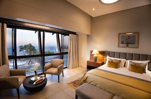 a bedroom with a bed and a large window at Angels View Hotel in Graskop