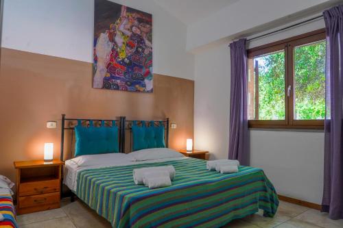 um quarto com uma cama grande com lençóis azuis e verdes em Agriturismo Il Roseto em Marina di Grosseto