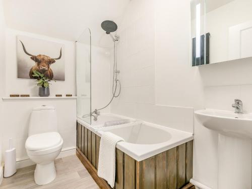 a white bathroom with a toilet and a sink at Sycamore Cottage in Praze an Beeble