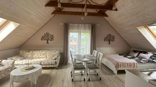 - un salon mansardé avec un canapé et une table dans l'établissement Karpacz-Sosnówka apartamenty butikowe z widokiem na góry, à Sosnówka