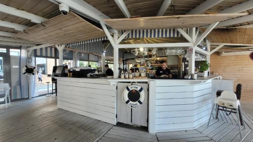 a bar in a restaurant with a man standing at the counter at Hotel Lambert Medical Spa in Ustronie Morskie